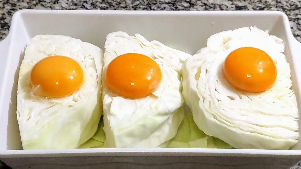 Pedaços de repolho com gemas de ovo por cima em travessa branca, capa da receita de repolho com ovos refogado